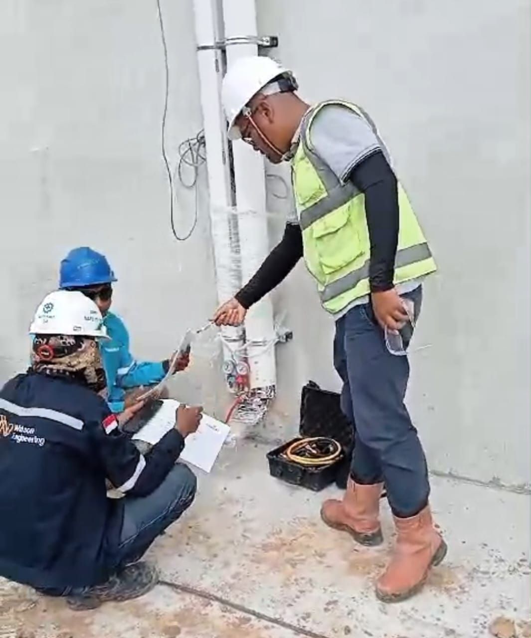 Engineer dan teknisi memeriksa wiring kontrol unit tata udara