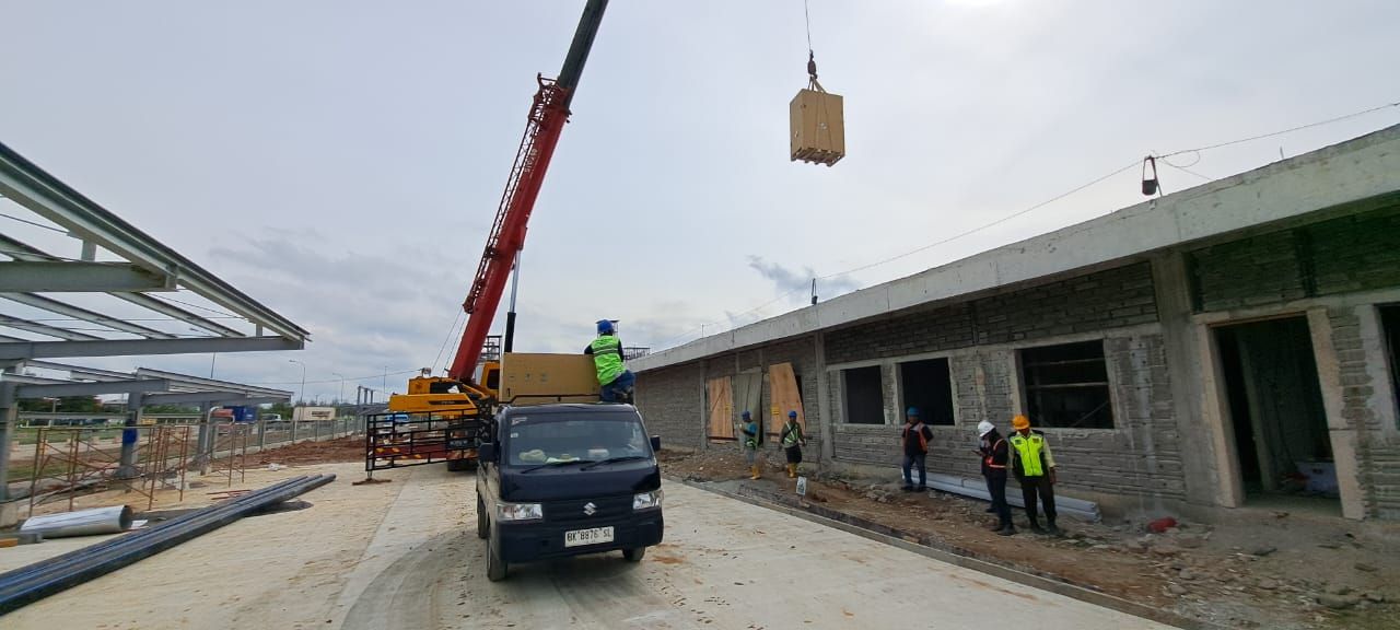 Crane mengangkat unit tata udara ke atap bangunan
